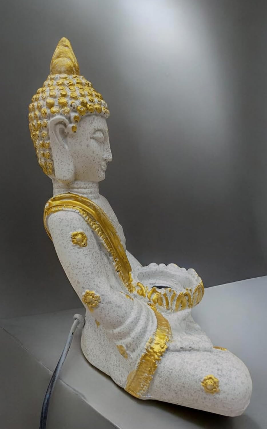 White and gold Buddha sculpture for home decor with intricate detailing and serene posture