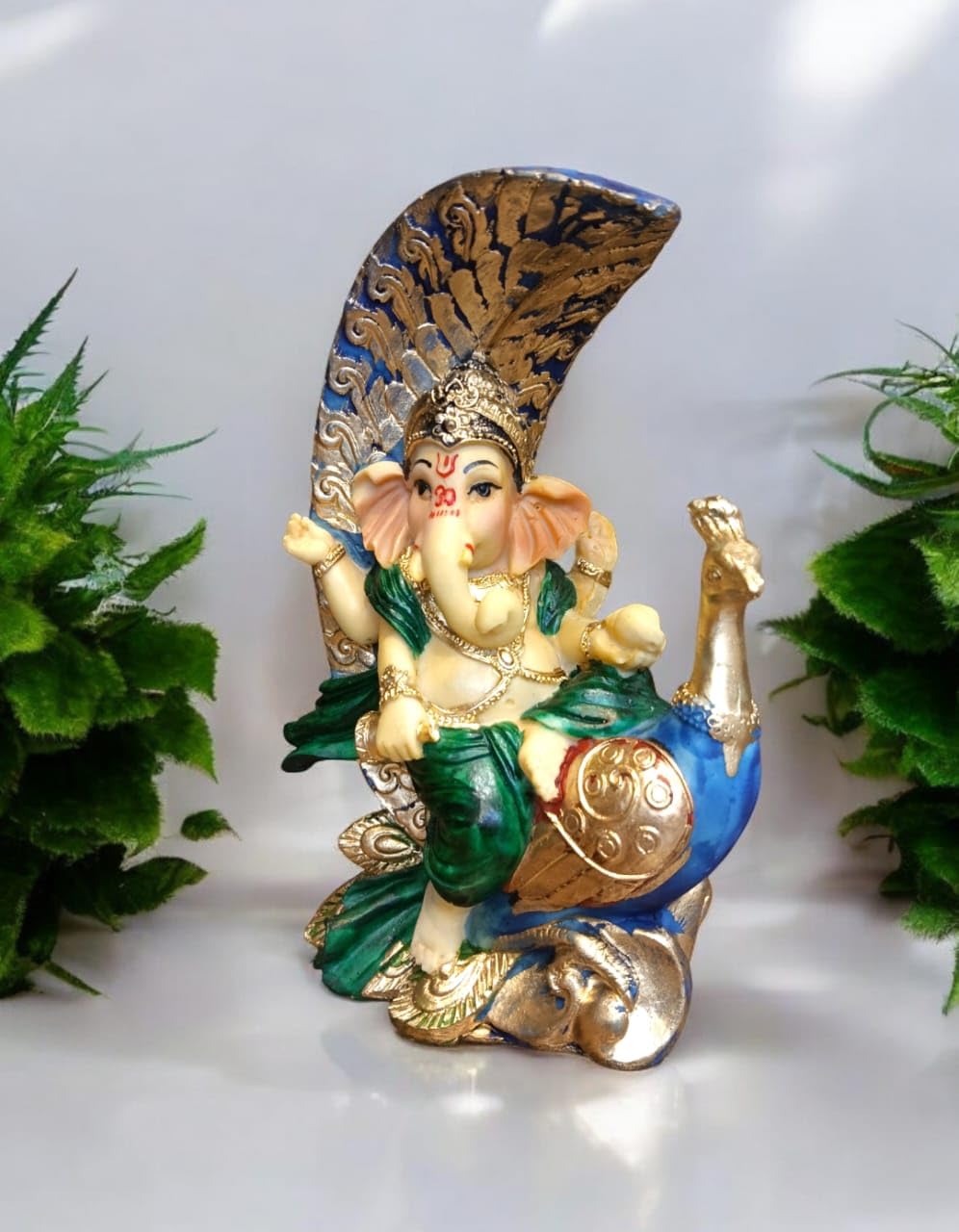 Decorative Ganesha idol with peacock, intricately designed with colorful accents and detailed features