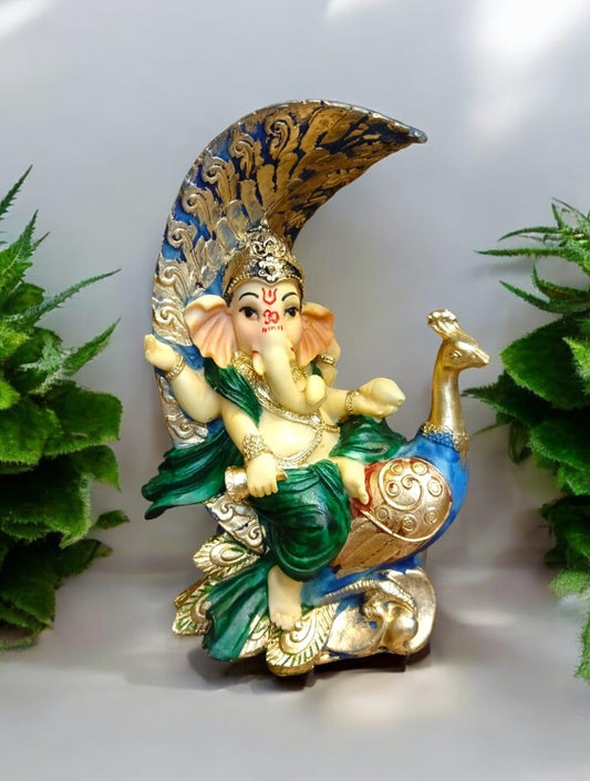 Decorative Ganesha idol with peacock on a beautifully detailed base surrounded by greenery