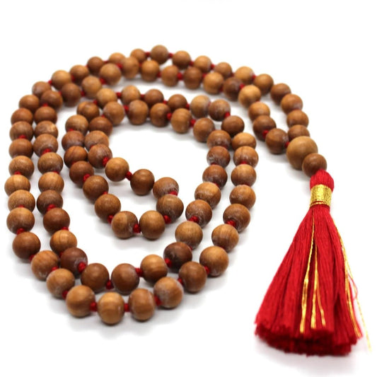 Sandalwood jaap mala for pooja with red tassel and wooden beads, ideal for spiritual practices.