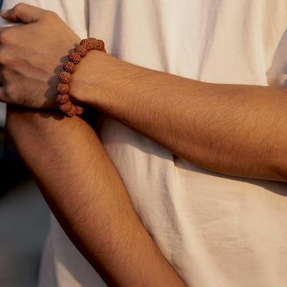 Traditional rudraksha beads accessory bracelet worn on a person's wrist in natural light